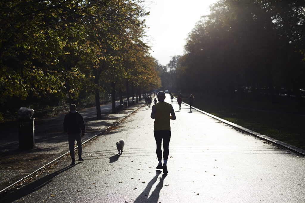 Silhouette of a person running towards a bright horizon.