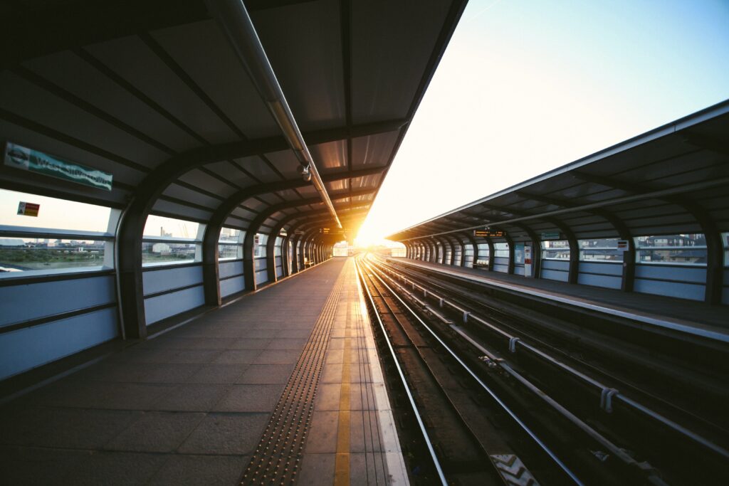 an empty train platform with sun rising in the horizon.