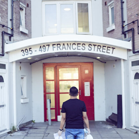 person standing outside a block of flats