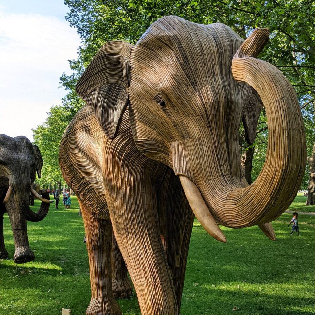 A large wooden elephant in the park.