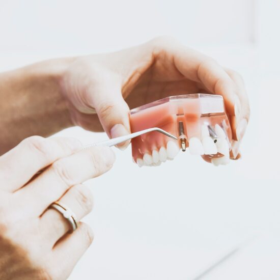 Woman holding dentures and a dental tool