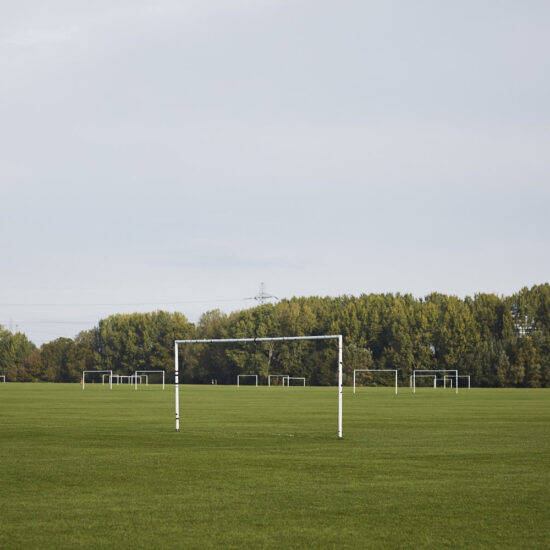 Empty goal in a field with hedgerows in the background