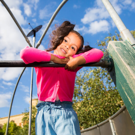 Young girl outside smiling at camera