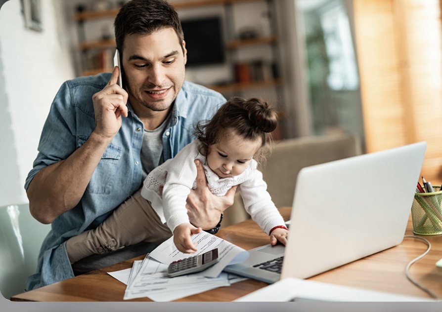 Dad working with baby in his arms, holding a phone