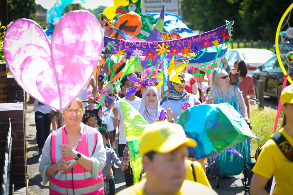 A crowd of people wearing hi-vis jackets, holding banners and streamers.