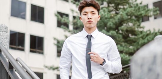 A young Asian man wearing shirt and tie, looking determinedly into the distance.