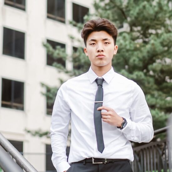 A young Asian man wearing shirt and tie, looking determinedly into the distance.