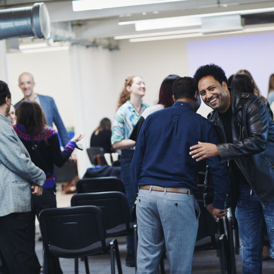 Renaisi colleagues greeting each other happily.